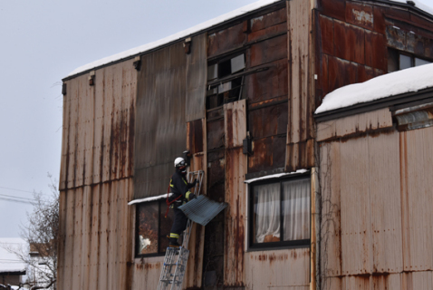 建物の外壁がはがれ、消防が出動した＝7日、鶴岡市山王町