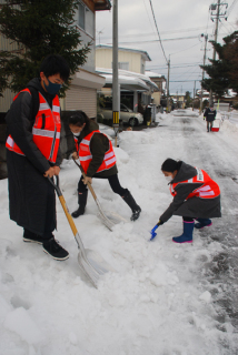 鶴岡の第一学区内の民家で除雪ボランティアを行う児童・生徒たち