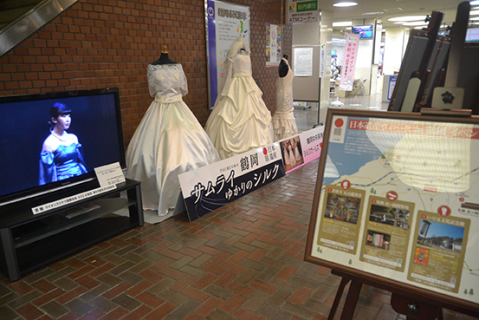日本遺産ウイークがスタートし、鶴岡の３つの日本遺産を紹介するパネルやシルクドレスなどが展示された＝８日、鶴岡市役所