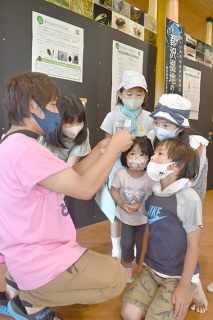 上山副館長（左）のギャラリートークを聴く子どもたち＝23日