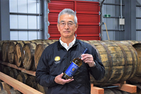 来年 2 月に発売する県産初のウイスキーを手にする佐々木社長