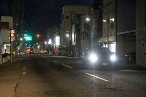 飲食店の看板の明かりが少なく、いつもより暗い鶴岡市の昭和通り＝27日夜