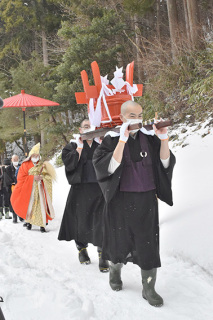 本堂の龍神へおけを運ぶ僧侶たち