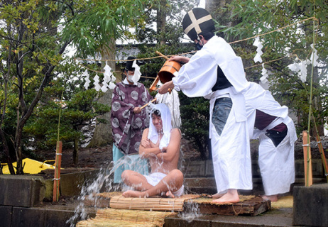 神社境内で冷水を浴び、身を清める佐藤さん（中央）