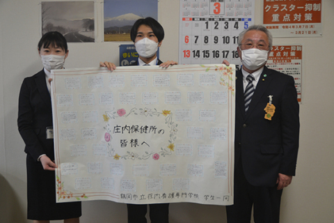 庄内保健所へ激励メッセージを贈った荘内看護専門学校学生自治会の金井さん（中央）と大場さん（左）