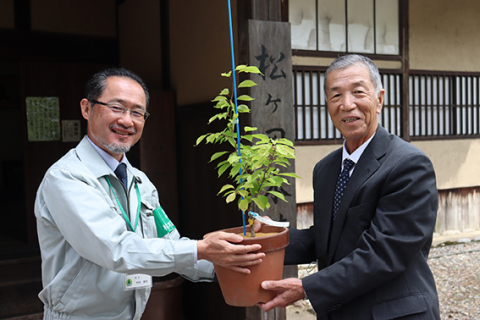 中村場長から 2 代目の「カスミ桜」を受ける堀理事長（右）