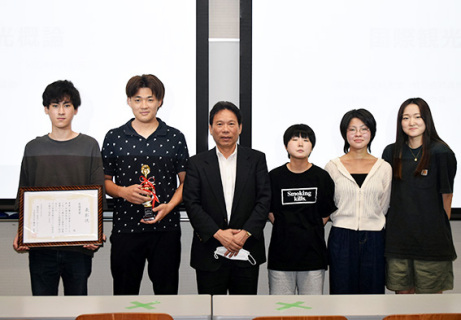 江さん（左から3人目）を囲む最優秀賞を獲得した学生グループ＝5日午後