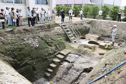 鶴岡南高敷地内で行われた鶴ケ岡城跡発掘調査の現地説明会。米蔵「七ツ蔵」を取り囲んでいた堀の一部が、初めて確認された＝11日