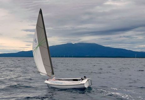 鳥海山を背景に自律航行する帆船型ドローン＝23日午前、エバーブルーテクノロジーズ提供