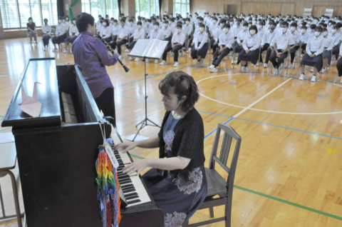 小野寺さん（手前中央）が弾く被爆ピアノと草刈さんのクラリネットの合奏に、鶴二中の生徒が耳を傾けた