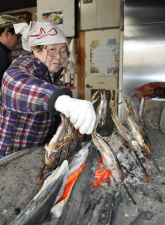 鮮魚店でハタハタを焼く“いつもの光景”が見られたが、昨年から続く不漁が店、客の両方に影響を与えている＝9日午前、鶴岡市の三浦佐五兵衛鮮魚店