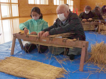 地域のお年寄りと俵編みに挑戦する新堀小児童