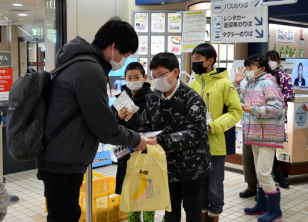 空港内で自ら手掛けた米を配布する東郷小の児童たち