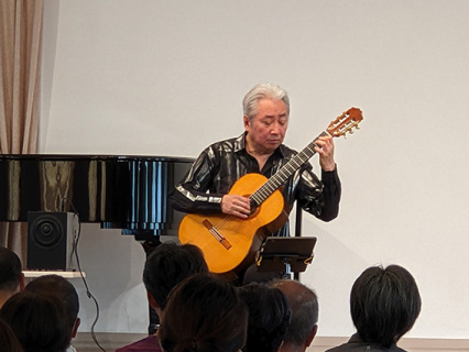 ギターブームの全盛期を思わせる雰囲気の明治ホールの中で演奏する福田さん