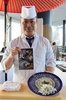 ＤＶＤと自ら手掛けたフグ刺しを持つ須田料理長