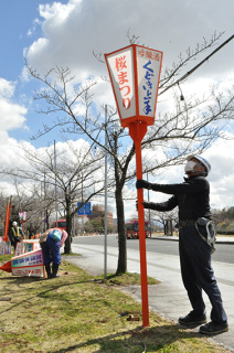 鶴岡公園南側の県道沿いで花見ぼんぼりの設置が進められた＝27日