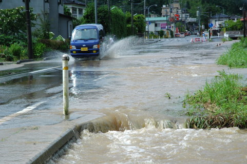 用水路から道路に水があふれた県道湯田川大山線＝午前9時ごろ