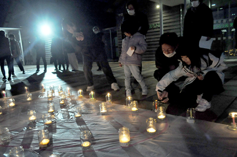 市民有志が約100本のろうそくに明かりをともし、東日本大震災の犠牲者の冥福を祈った＝鶴岡まちなかキネマ