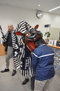 来店者や鶴岡信金職員が厄よけのため獅子から頭をかんでもらった