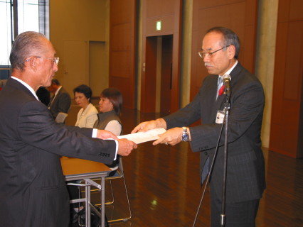 山口県教育長（右）が星川委員長に構想検討依頼書を手渡した