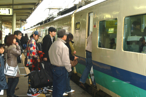 大きな荷物を手に特急列車に乗り込むＵターン客たち＝3日、ＪＲ鶴岡駅