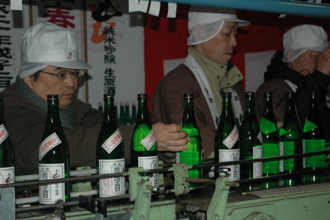 立春朝搾りのラベル張り作業をする日本名門酒会のメンバー