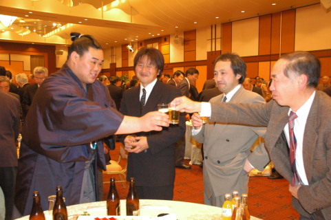 十両昇進を祝う会で、後援者と祝いの酒を酌み交わす北勝国（左）