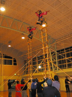 高さ約6メートルのはしご上で演技を披露する女性消防団員