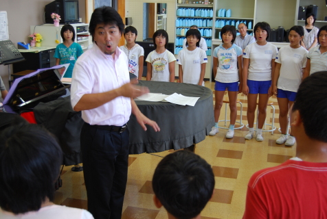 三川中の安達教諭の指導で歌う横山小の6年生
