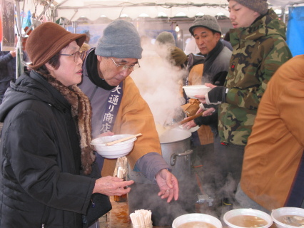 湯気を上げる大鍋の前に寒ダラ汁を買い求める観光客が並んだ