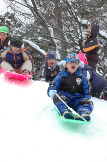 歓声を上げながらそり滑りを楽しむ園児たち＝18日午前10時ごろ、鶴岡市の鶴岡幼稚園