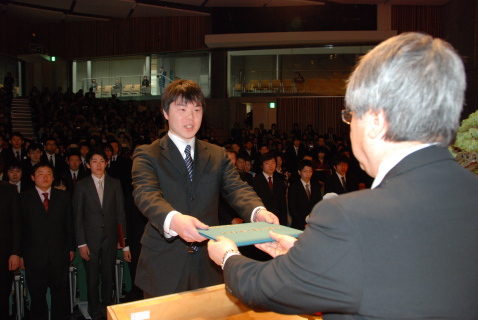 黒田学長（手前）から卒業生総代の百瀬さんに卒業証書が授与された