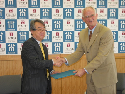 協定書に署名後、握手を交わす黒田学長（左）とストロナク学長