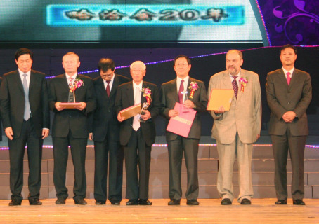 新田氏（中央）らに功勲章が贈られた＝ハルビン市国際会議展示センター