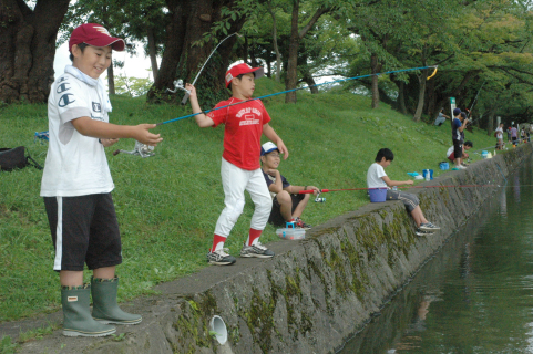 鶴岡公園子供釣り堀で釣りによるブラックバスの駆除に取り組む子供たち