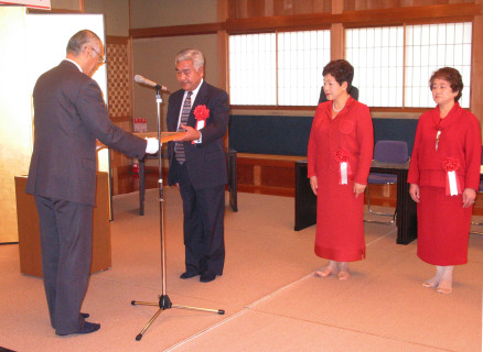 ?橋委員長（左）が鈴木会長に表彰状を手渡した