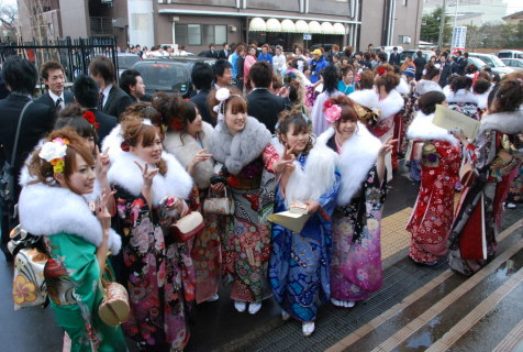 鶴岡市の成人式では、会場前に振り袖姿の新成人が集まり華やいだ雰囲気。あちこちで記念撮影をする姿が見られた＝鶴岡市文化会館