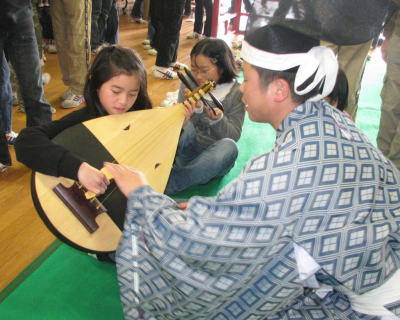 雅楽器に触れて伝統的な音楽を体験する児童たち