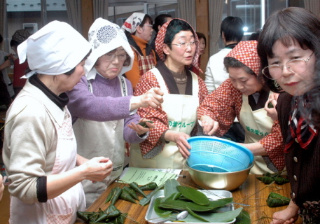 地元の女性に教わりながら参加者が笹巻き作りに挑戦