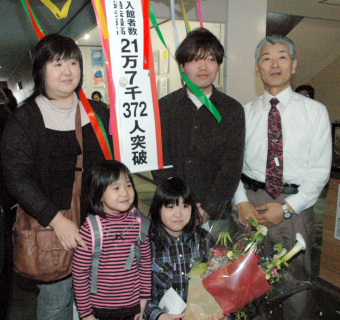 村上館長（右）が新記録達成の入館者となった菅野さん親子と記念撮影