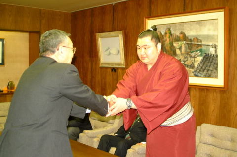 榎本市長（左）に昇進を報告し、握手を交わす上林関