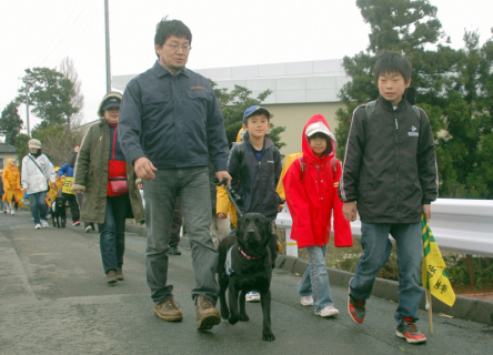 嘱託警察犬とともに集団下校する児童たち＝22日、広野小近く