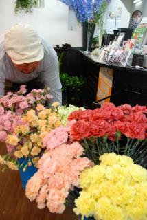 さまざまな色のカーネーションが並び、アレンジメント作りに大忙し＝8日、鶴岡市の「花蔵」