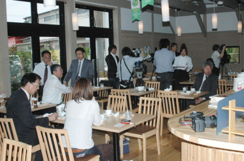 「良い食の会」の加盟店を示す「グリーンフラッグ」が天井からつり下げられたヒラボク食堂で新田社長（左）が解説した