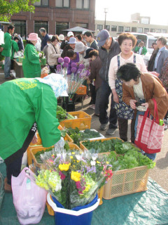 旬の野菜と水産物を求める大勢の市民でにぎわった市役所駐車場の朝市