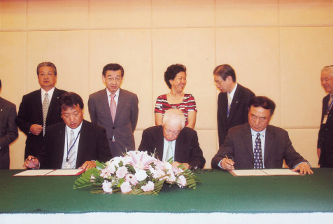 新田会長（手前中央）、今野組合長（同左）、桑会長（同右）が、つや姫の輸出入協定に調印した＝15日、中国・ハルビン市