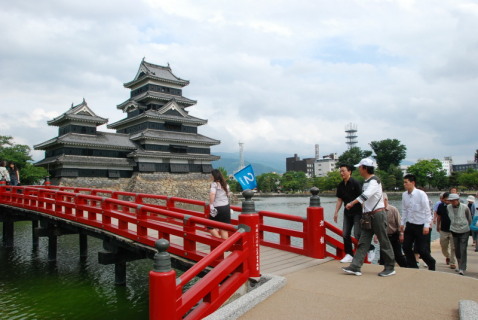松本城を見学するツアー参加者たち＝13日