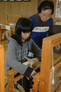地元の女性たちの手ほどきを受け、機織りによるコースター作りに挑戦