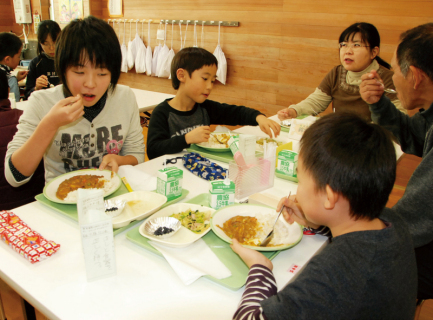 給食で里芋カレーなどをおいしそうに頬張る子供たち＝羽黒四小