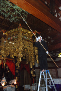 復興の祈りを込めながら、本堂の高い天井のすすを払う善寳寺の僧侶たち